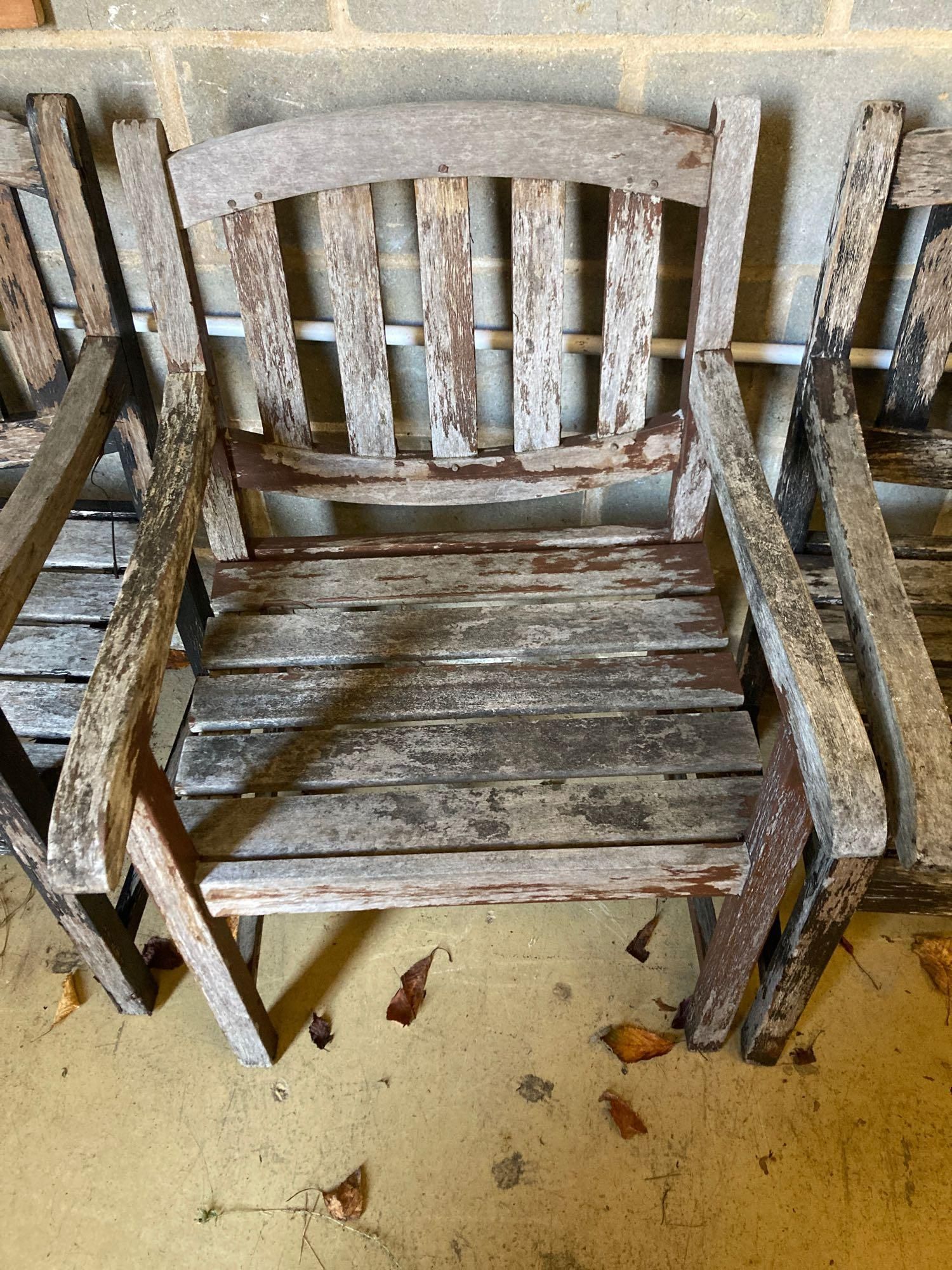 Two stained teak garden benches and matching armchairs, bench widths 126cm and 123cm